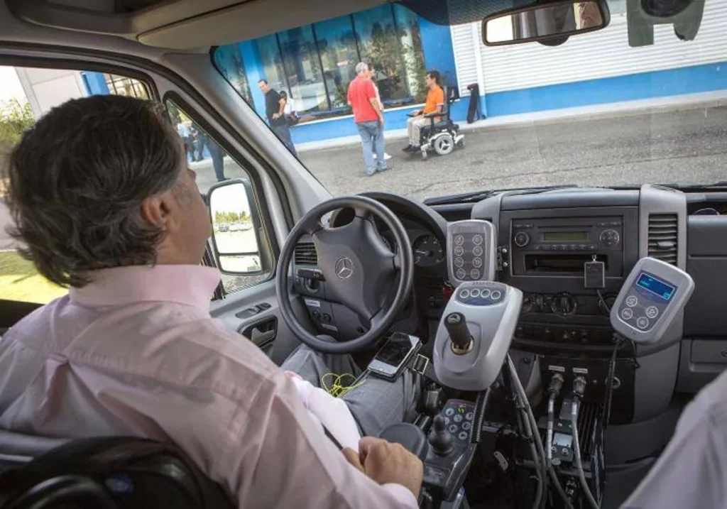 Persona con discapacidad física conduciendo un coche adaptado