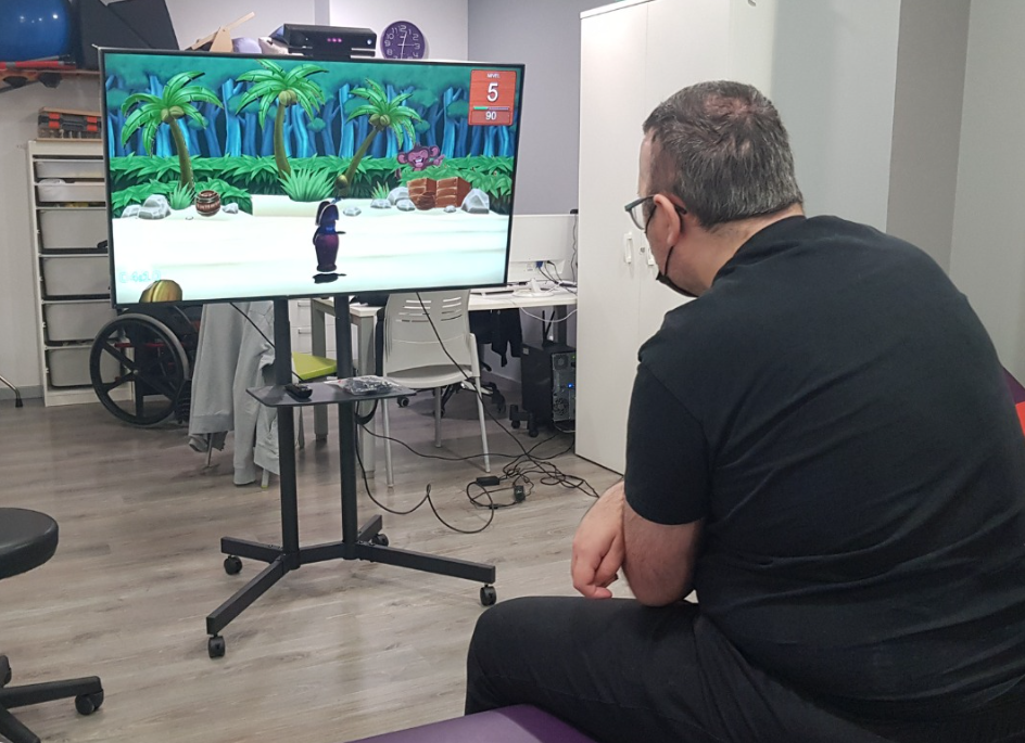 Terapeuta observando a un paciente frente a una pantalla en un ejercicio de control de tronco